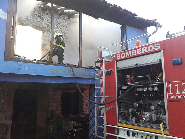 Bomberos del 112 trabajan en la extinción de un incendio en una vivienda en Udías