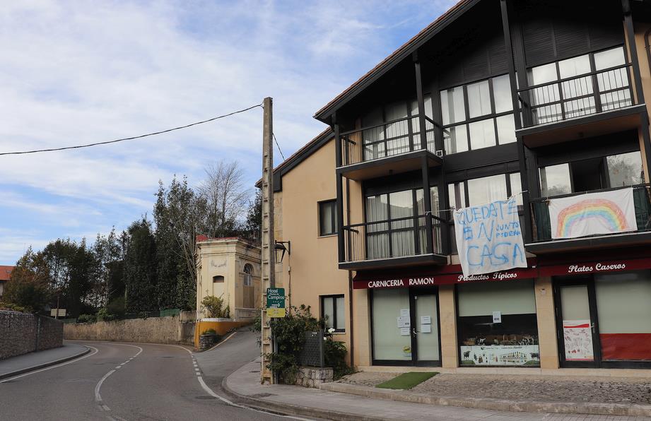 En la entrada de Comillas, varias casas muestran pancartas con el lema "Quédate en casa"